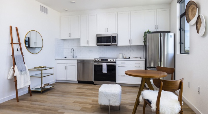 Kitchen flows into living space kitchen on wood-style flooring and with easy access to the living room