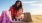 lifestyle image of a woman and a boy making sand castles in the beach